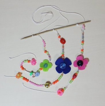 Make a pretty pendant with beads and buttons!