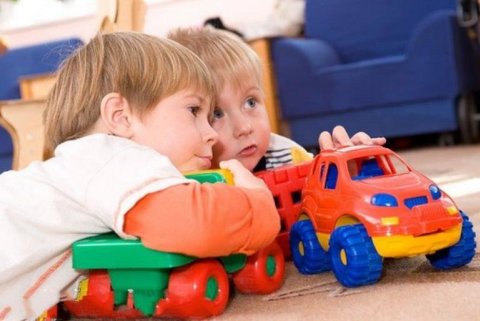 Два мальчика общаются, играя с машинками дома