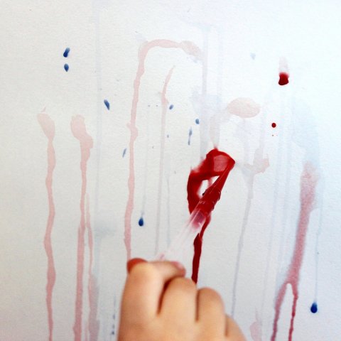 ребенок выдавливает краску из пипеток на лист бумаги необычный способ рисования