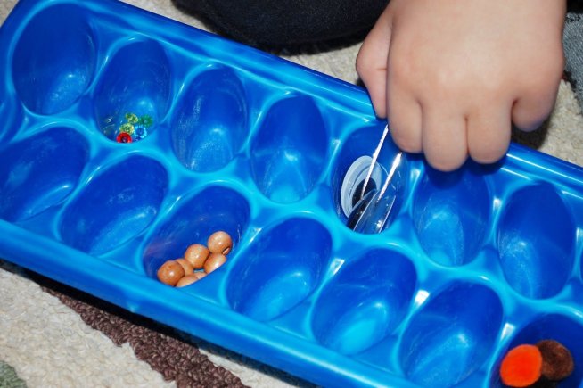 Предложите ребенку поиграть с формой для льда и пинцетом